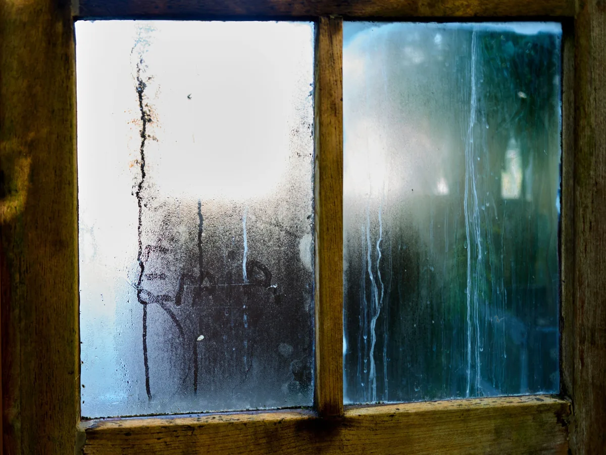 Buée et gouttes de condensation sur une vitre intérieure